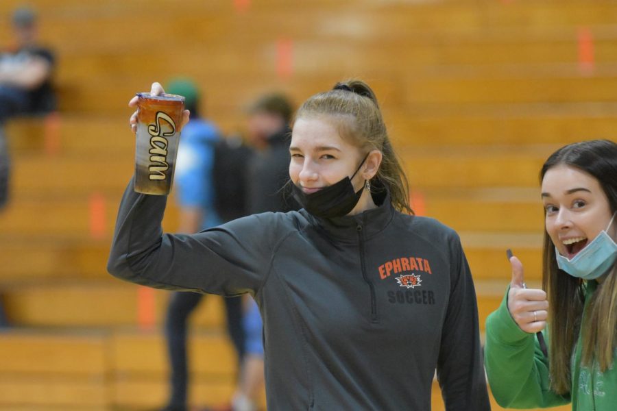 ASB officers, Samantha MacNeil (left) and Rashann Olsen stop for a moment to show their excitement before opening the spring sports assembly at Ephrata High School today. (March 5, 2022)